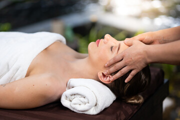 Obraz na płótnie Canvas happy beautiful caucasian woman enjoying head massage at the spa and wellness center