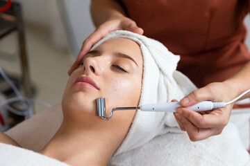 Tools facial mask treatment. Beautiful caucasian woman getting face massage in beauty spa and wellness center. Facial treatment and skin care concept.