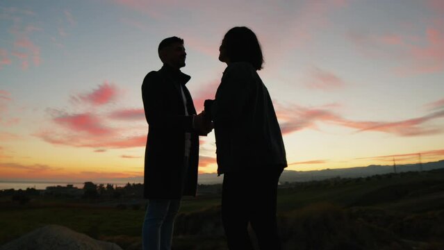 Couple dance against sunset sky in silhouette for valentine's day
