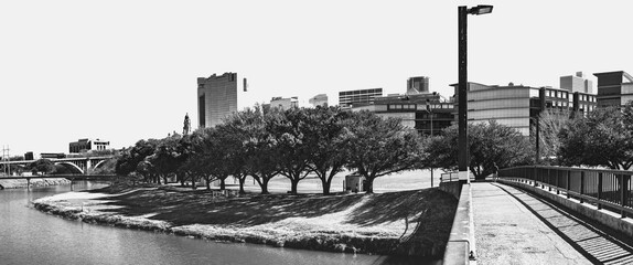 Fort Worth city skyline and buildings in black and white photography over the Trinity River Park Bridge, and nature trails in Texas, USA, modern cityscape with open space