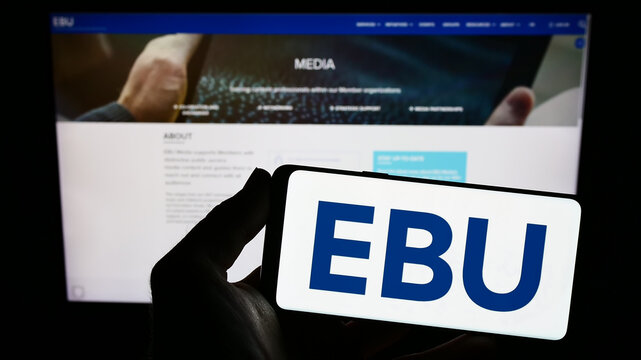 Stuttgart, Germany - 01-22-2023: Person holding smartphone with logo of European European Broadcasting Union (EBU) on screen in front of website. Focus on phone display.