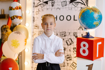 schoolgirl in the classroom at the lesson. Back to school concept.  Clever child in elementary school. The first time in first class. Smart Pupil make science. Handsome junior girl portrait