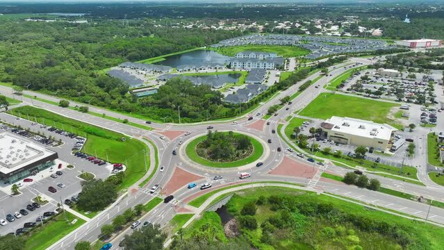 Aerial view of road roundabout intersection with fast moving heavy traffic. Urban circular transportation crossroads