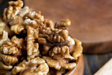 Peeled walnuts in a wooden bowl on the table