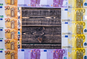 Euro banknotes on a wooden background with a place to copy.