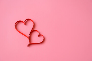 Two red paper hearts on a pink background. Background for Valentine. Valentine's Day. Love concept.