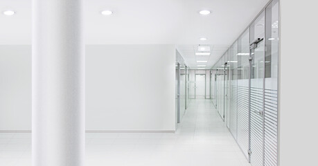 An empty office hall and corridor with glass walls, doors, and a column in the foreground