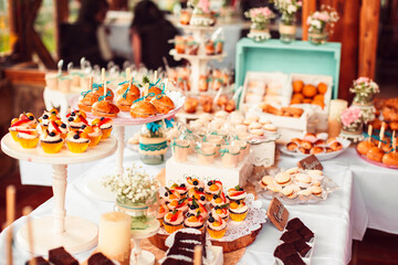 Table with lots of cakes, cupcakes, cookies and brownies