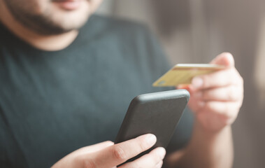Online payment, man hands using a credit card payment online shopping with a smartphone application. Digital money transfer, banking and e-commerce