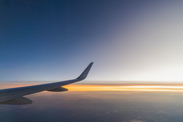 Beautiful sunset, sky on the top view, airplane flying view from inside window aircraft of...