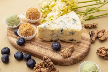 Cheese plate. Cheese, candies, walnuts and berries. A piece of dor blue cheese