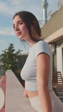VERTICAL VIDEO, Young woman enjoying beautiful view while standing on the balcony