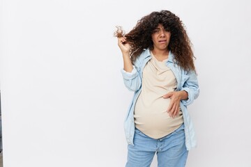 Pregnant woman hair loss during pregnancy, health problems and vitamin deficiencies on a white isolated background in a t-shirt with a blue shirt