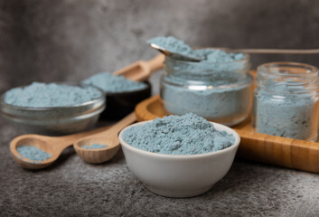 Blue spirulina powder in bowls and spoon on black marble background. Natural vegan superfood. food supplement. place for text. Copy space.