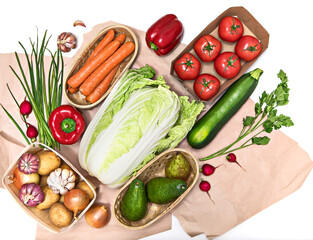 A variety of organically grown vegetables are stacked diagonally on rough paper or in packaging. Healthy food concept, organic food, kitchen ingredients