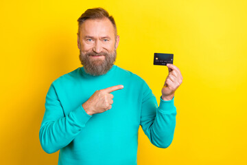 Photo of successful positive man wear stylish trendy clothes demonstrates debit card nfc functions...