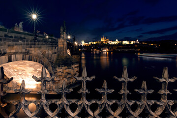 Nocny krajobraz pięknej Pragi.  Most na rzece. Zamek w Pradze w nocnej scenerii