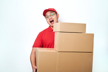 Smiling happy asian delivery man in red courier uniform, looking behind boxes with client orders, carry parcels to client home