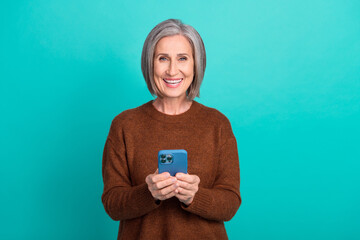 Photo of positive pretty lady toothy smile hold use telephone isolated on cyan color background