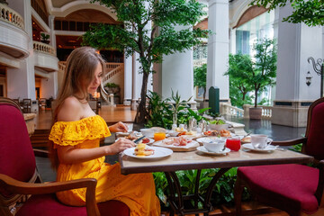 Woman Enjoying breakfast meal in Luxury Restaurant in modern resort or hotel