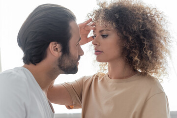 bearded man and sexy woman with curly hair looking at each other.
