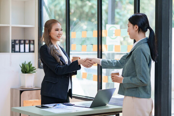 Asian Businesswoman shaking hands to confirm agreement in business for mutual investment and agree on a unified work contract.
