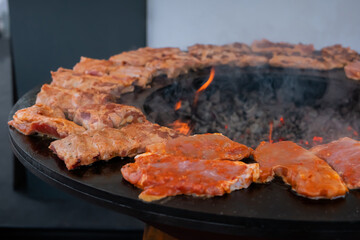 Close up: process of cooking fresh juicy meat steaks on brazier at summer local food market. Outdoor cooking, gastronomy, cookery, street food concept