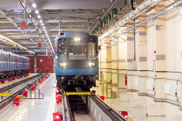 Electric locomotive metro subway with headlights on arrived at the depot. Passenger trains arriving for service at the electric depot.