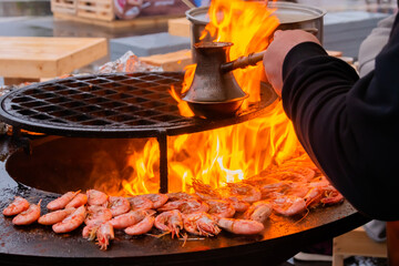 Process of grilling fresh red king prawns and preparing Turkish coffee with black cezve or ibrik on...