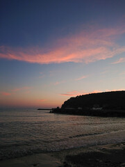 Sunset on the sea. Red clouds in the blue sky