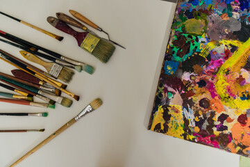 Obraz premium paint brushes lie next to the artist's paint palette