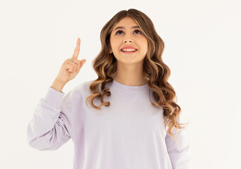 Thoughtful smiling woman with dark hair, raising finger and pointing up, having good point or idea, showing advertisement, standing against white background