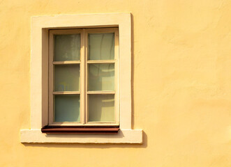 little old window in yellow wall
