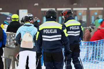 Patrol narciarski policji na nartach kontroluje ruch na stoku narciarskim. 