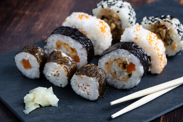 typical japanese sushi on a black slate board