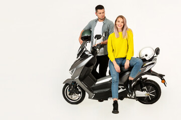 young attractive couple riding an electric motorbike scooter happy having fun together
