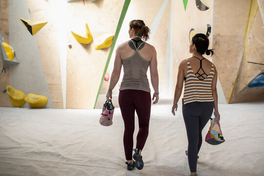 Female rock climbers with chalk bags in climbing center