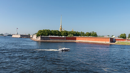 Obraz premium view from the Neva River to a moving motor boat and the Peter and Paul Fortress in the center of the city of St. Petersburg, Russia
