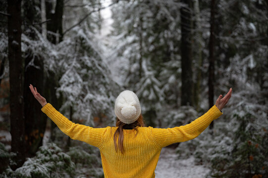 Woman enjoying life with her arms spread in white winter forest