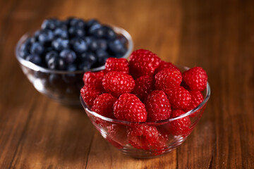Raspberries and blueberries on an wooden board