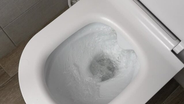 Flush toilet. Water flushes toilet. Flow of water is clearly visible. water in ceramic toilet. Retarded motion. Flow of water comes from mouth itself or beginning.