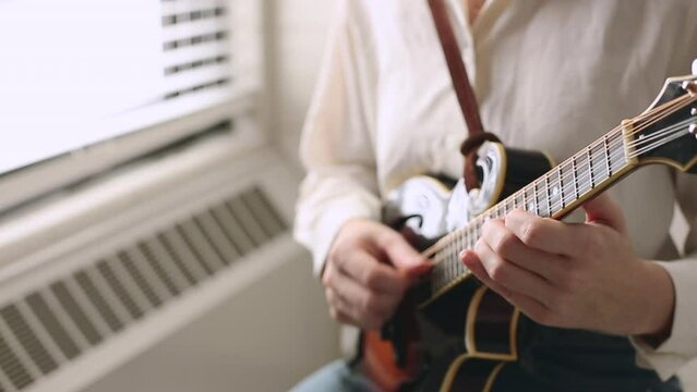 Close Up Young Woman's Hands Playing Mandolin, Practicing Bluegrass Instrument