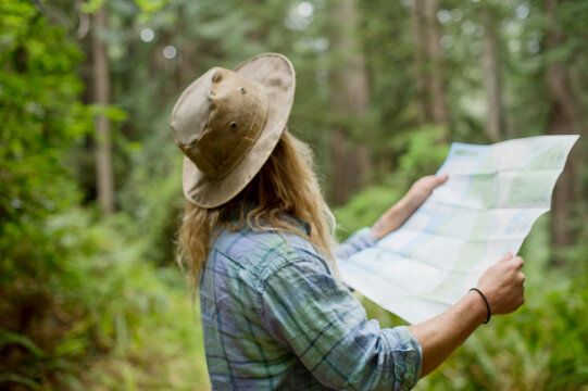 Man Looking At Map In Forest