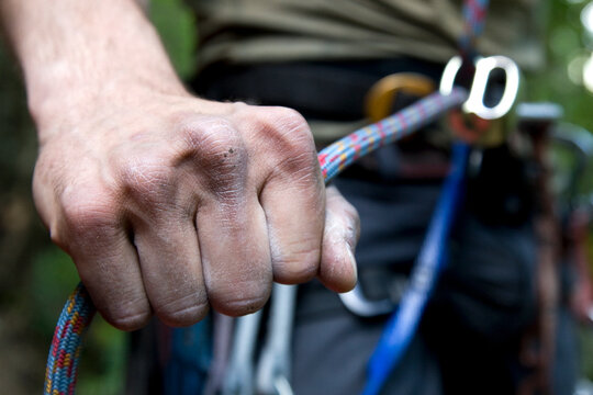 A hand holds the rope tight to prevent the climber above from falling far, Zig Zag, Oregon.