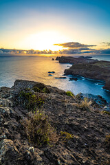 Panoramic view from a steep cliff over the seascape and along the rugged foothills of Madeira coast at sunrise. Ponta do Bode, Madeira Island, Portugal, Europe.