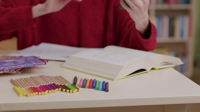 Female student studying in library distracted by notification on cellphone