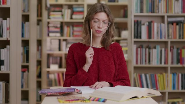 Young woman in library remembers while studying 