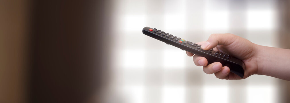concept - man with his remote control watching tv in his living room
