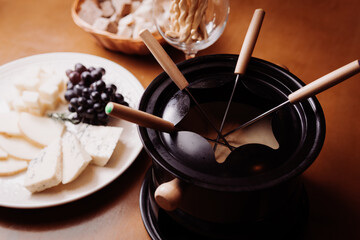  
Photo of a delicious cheese fondue, with grapes, bread, wonderful. Stylish photo for restaurants
