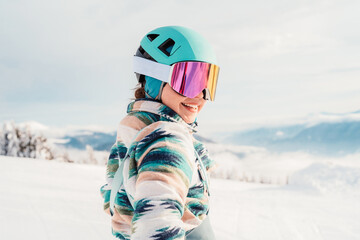 Woman in skiing clothes with helmet and ski googles on her head with ski sticks. Winter weather on...